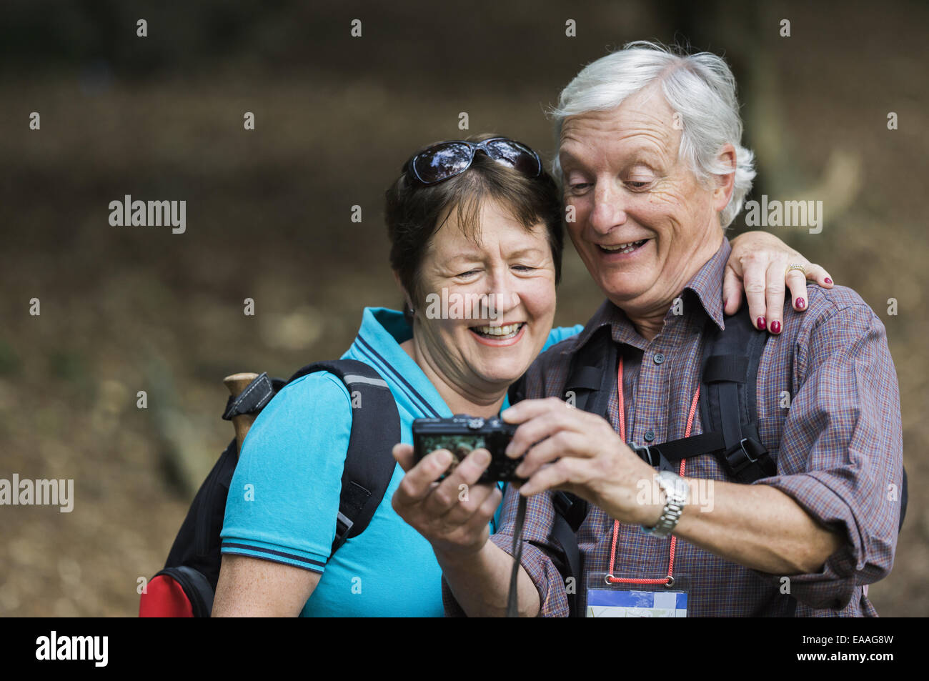 Una pareja madura busca en una cámara digital, riendo. Foto de stock