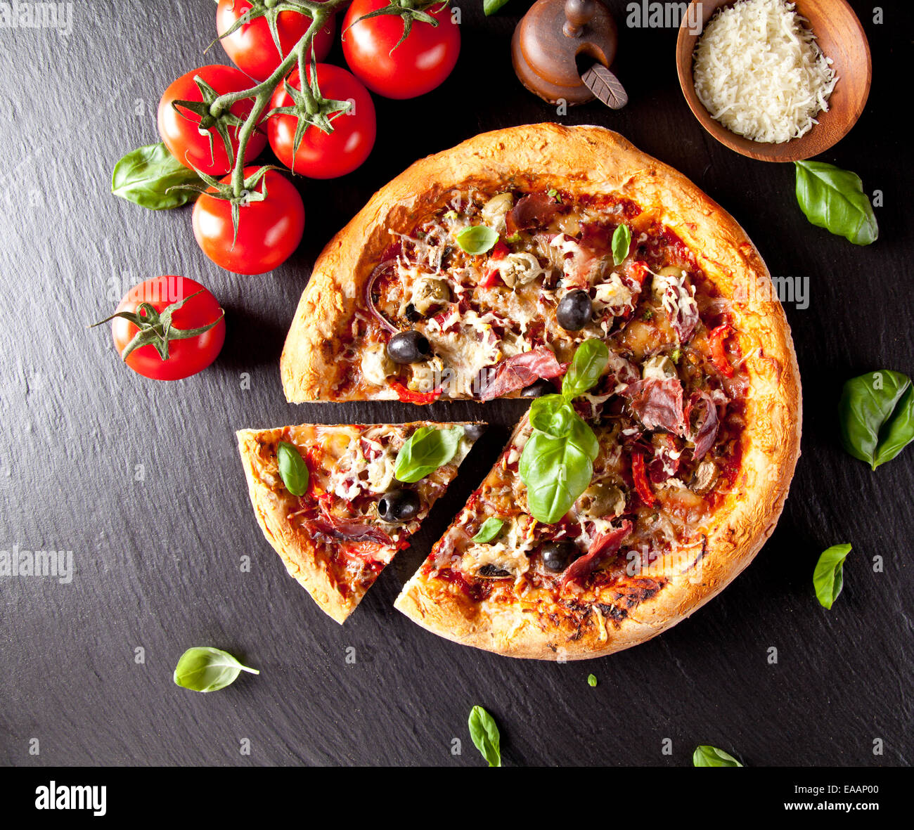 Hecho en casa la pizza italiana con verduras frescas. Servido en piedra  negra de la superficie. Disparo de vista superior Fotografía de stock -  Alamy