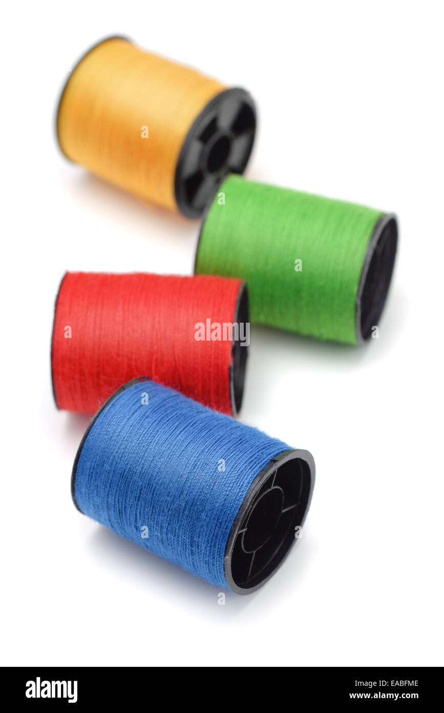 Cuatro bobinas de hilo de color aislado en blanco Foto de stock