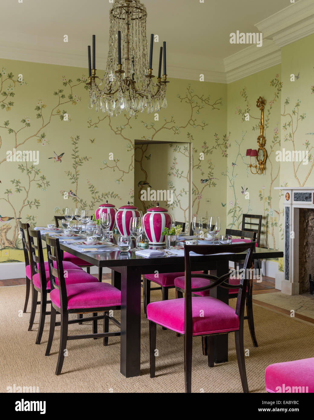 De Gournay Chinoiserie wallpaper en comedor francés con lámparas de araña de cristal y sillas de comedor tapizadas en Bruno ve triplete Foto de stock