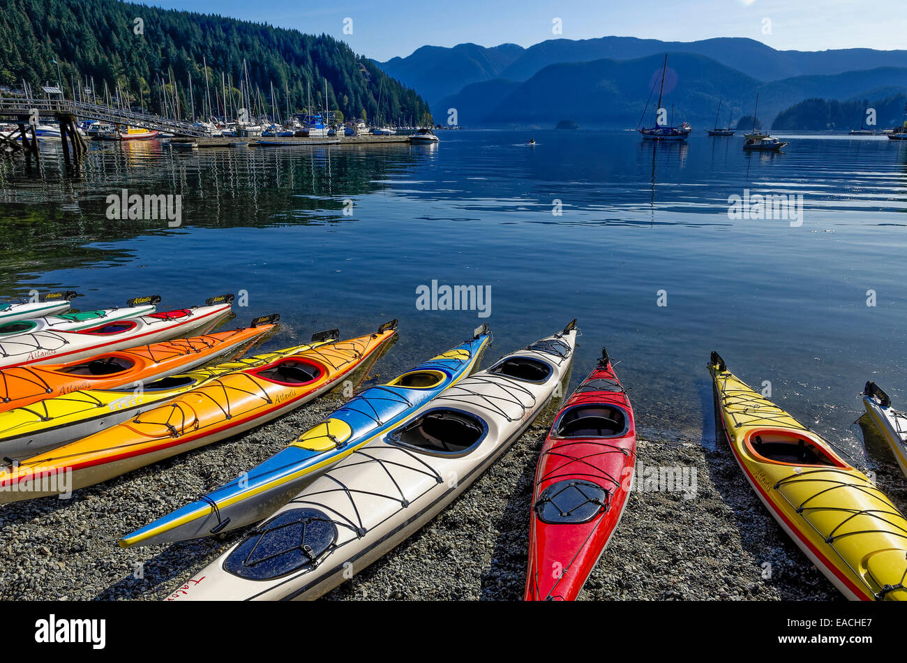 Coloridos kayaks están alineadas en la playa en Deep Cove Canoa y Kayak Centre. Deep Cove, distrito de North Vancouver, Britis Foto de stock