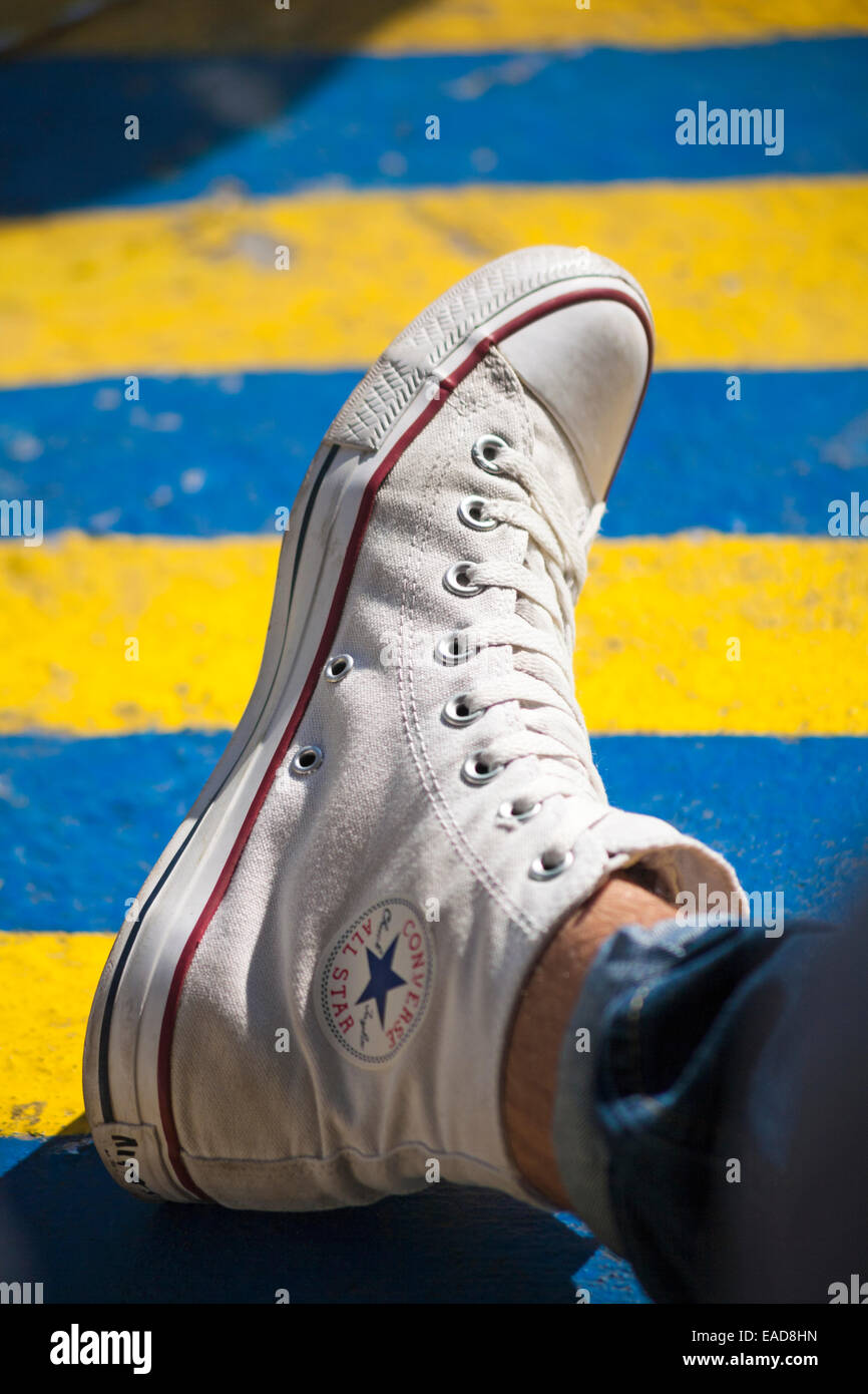 Converse All Star trainer está desgastada y descansando sobre suelos de rayas  azul y amarillo Fotografía de stock - Alamy