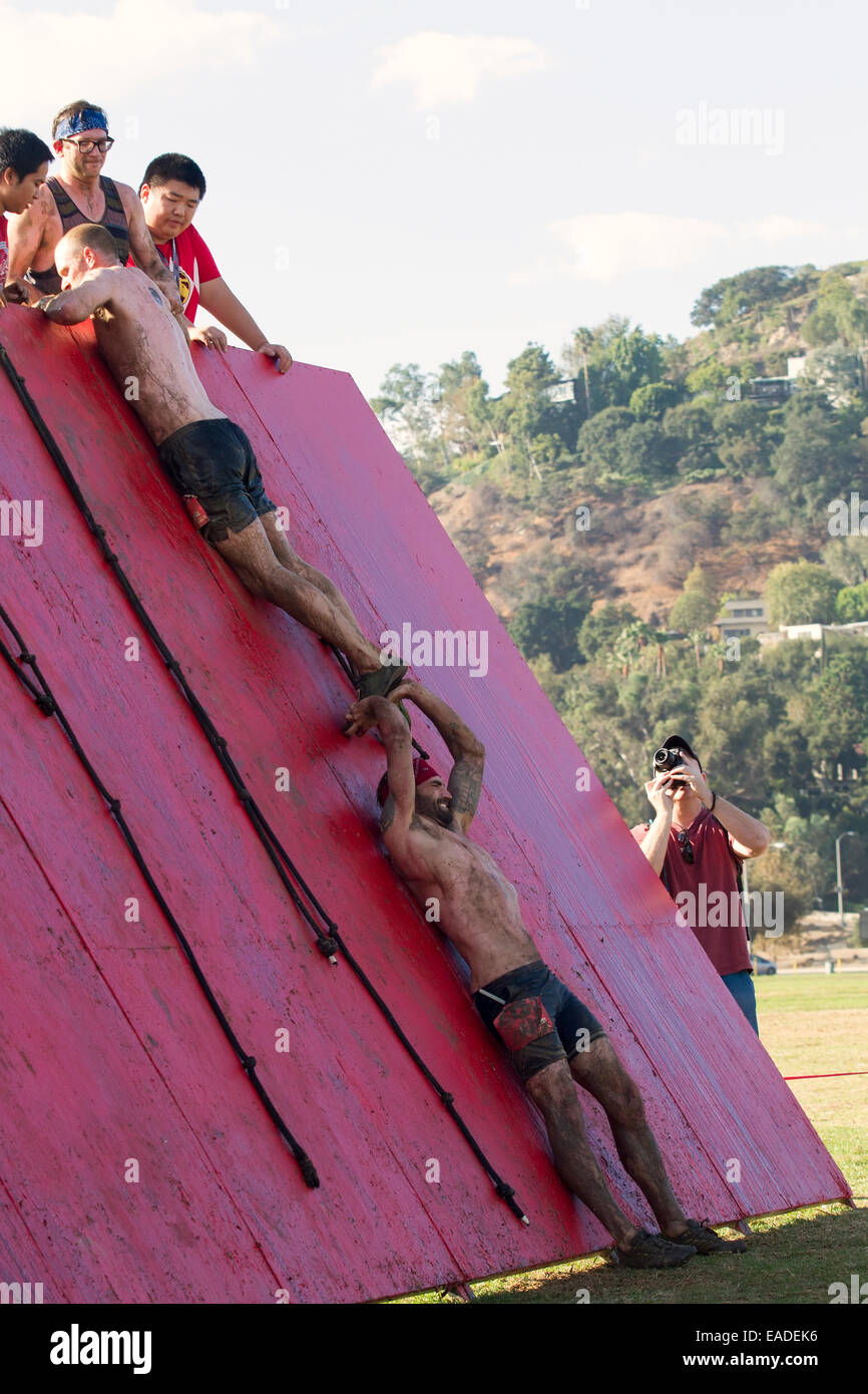 Los participantes escalar el "Muro de la vergüenza" en el espartano "Gladiator Rock'n' 5k carrera de obstáculos de Pasadena, California Foto de stock