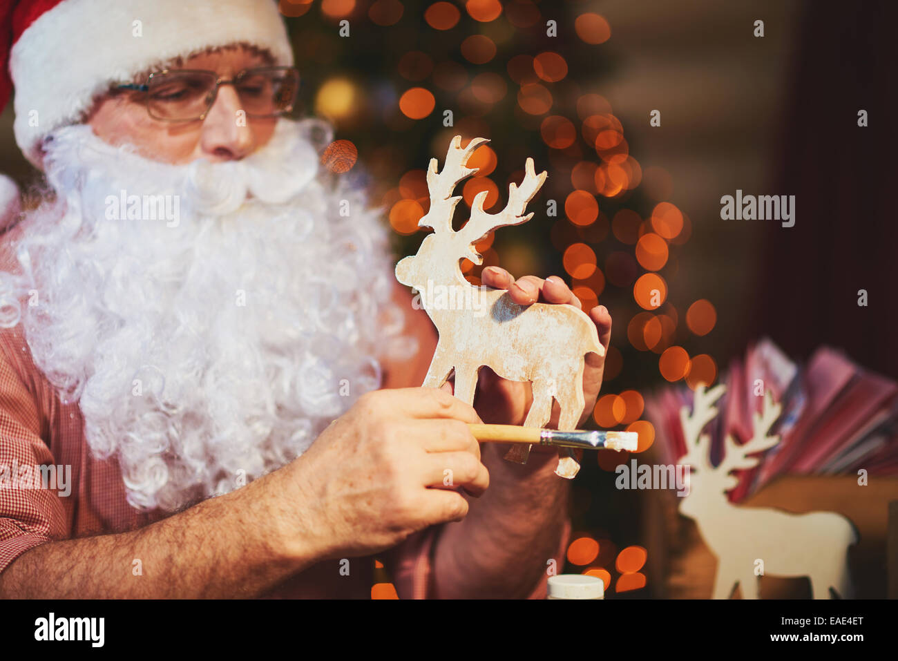 Altos Santa hombre sujetando ciervos en manos de madera Foto de stock