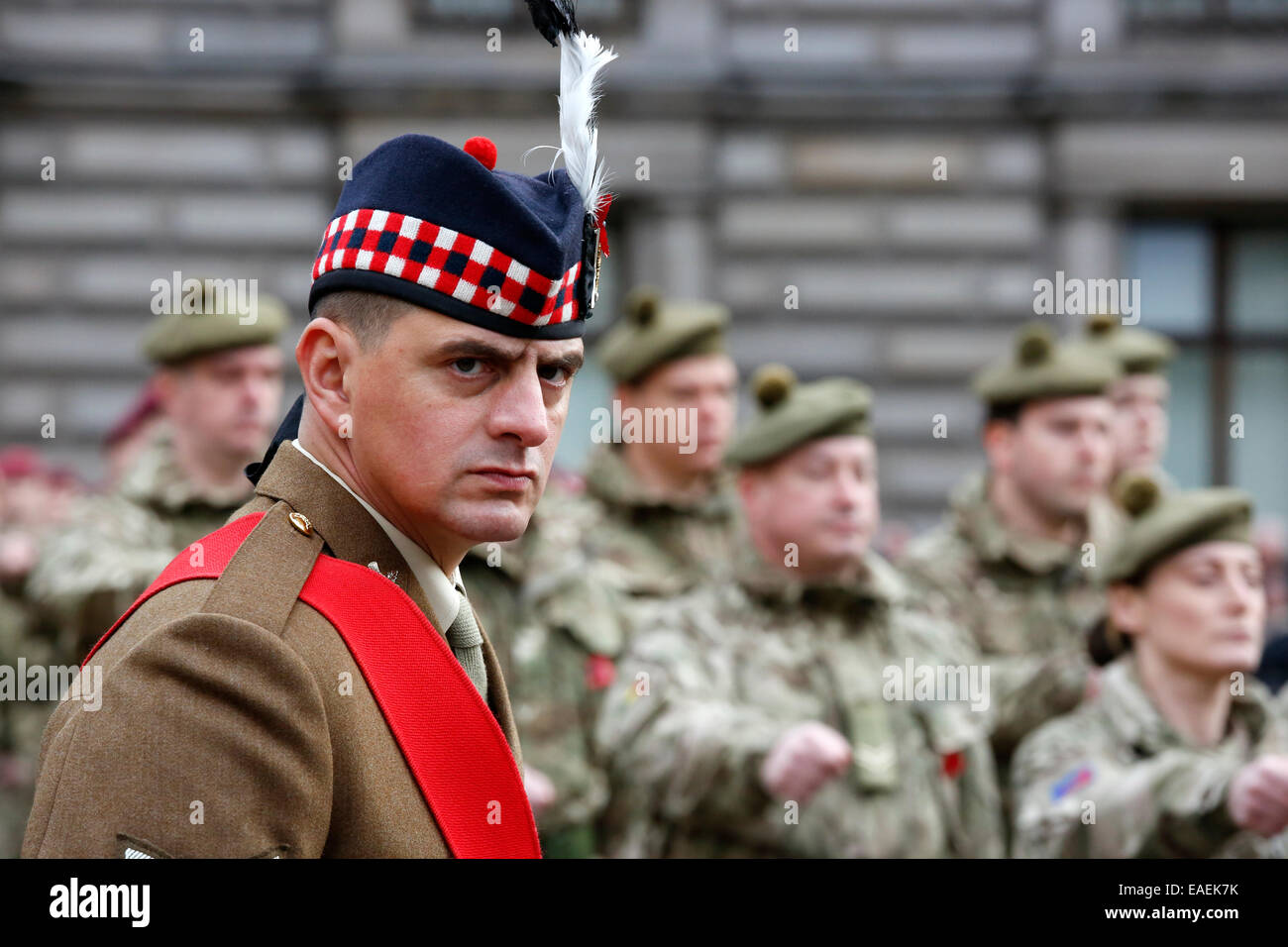 Soldado en un desfile con otros marchan en el fondo, Glasgow, Escocia, Reino Unido Foto de stock