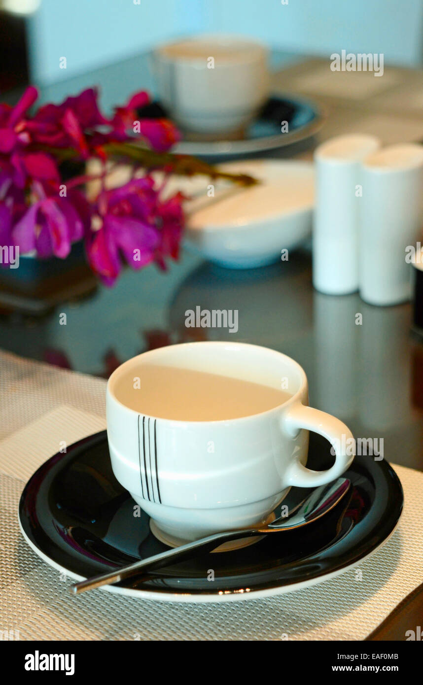 Lugar: un lugar con una taza de café, cristal y cubertería se configuran mediante un toque contemporáneo en un art decó. Foto de stock