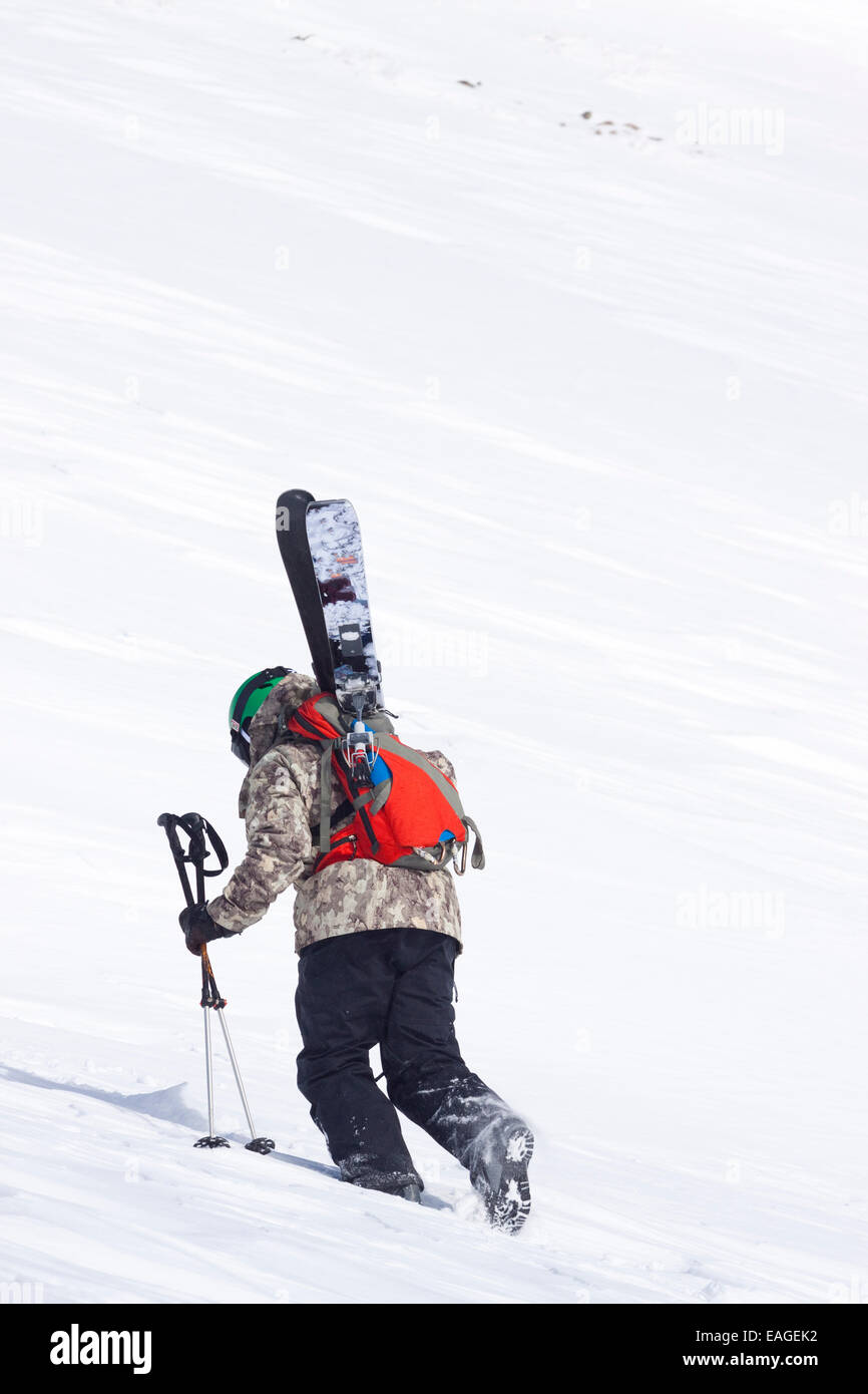 Un esquiador macho caminatas con su línea de esquí Big Sky Resort en Big Sky, Montana. Foto de stock