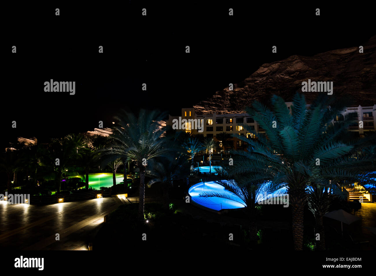 Escena nocturna con coloridas piscinas en un complejo de lujo. Omán. Foto de stock