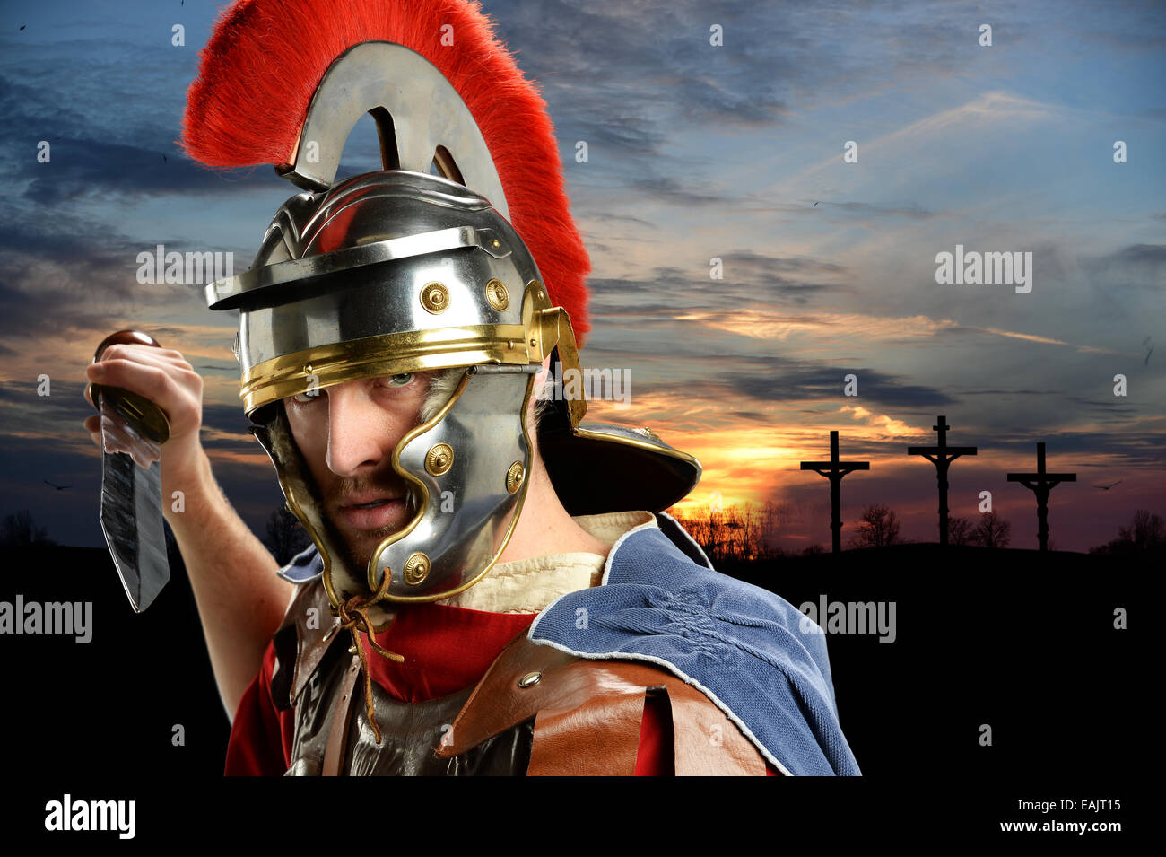 Retrato del soldado romano blandiendo la espada con la cruz del calvario y cruza al atardecer Foto de stock