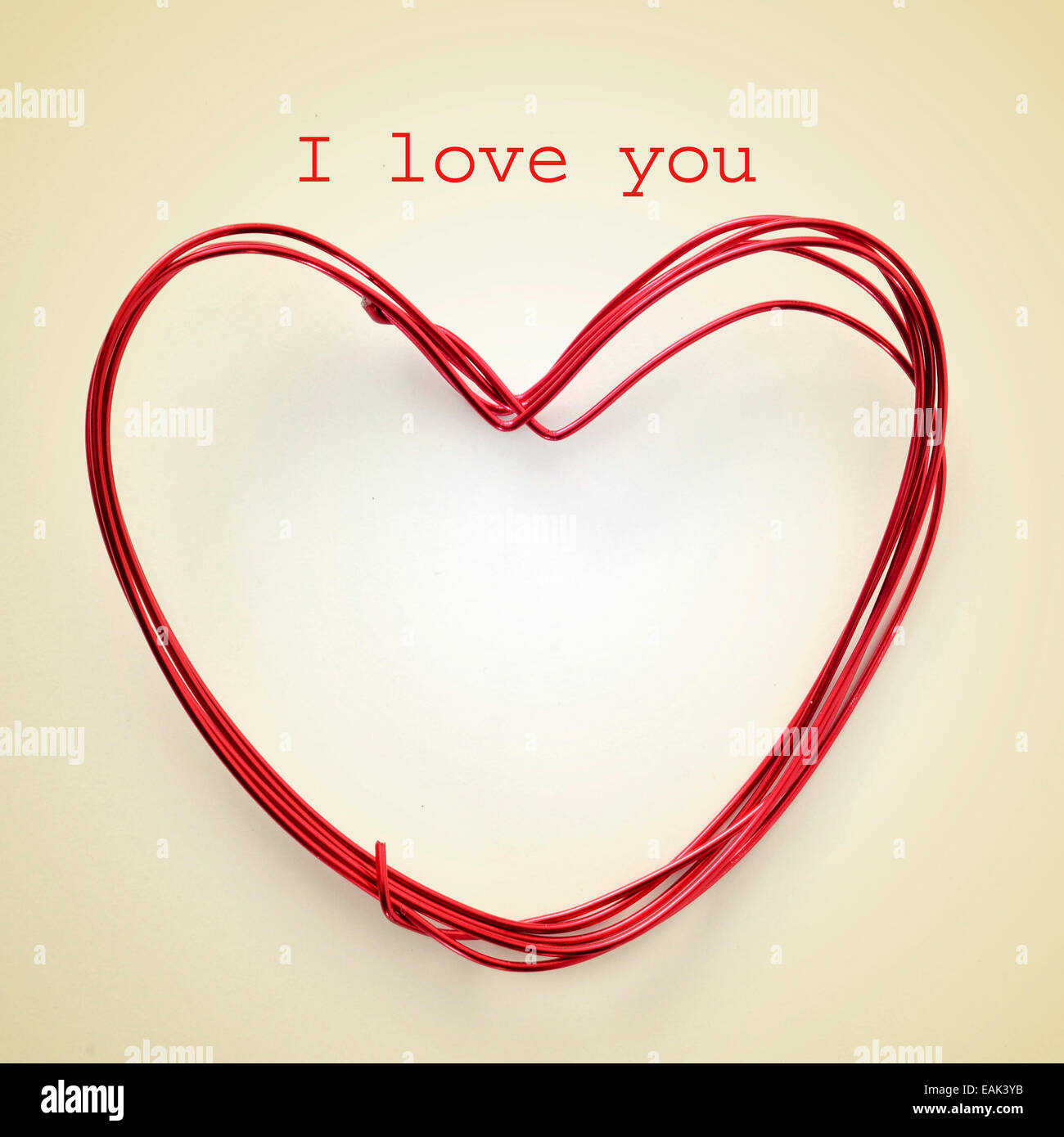Frase te amo y un corazón con forma de rollo de cable sobre un fondo de color beige, con un efecto retro Foto de stock