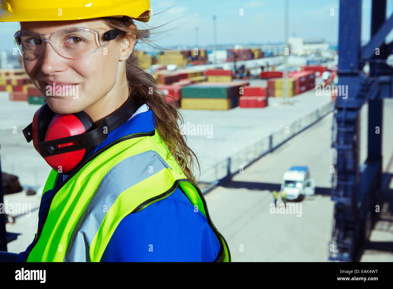 Trabajador sonriendo cerca de contenedores de carga Foto de stock