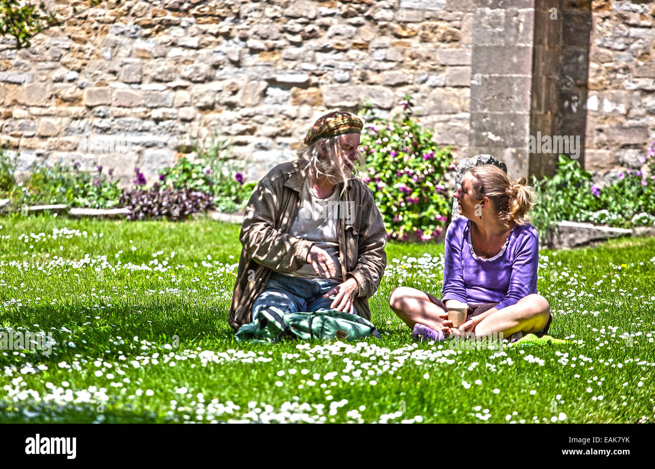 2 personas pueblo europeo, una hembra , 1 macho sentado en un campo y hablar en el Reino Unido durante el verano. Foto de stock