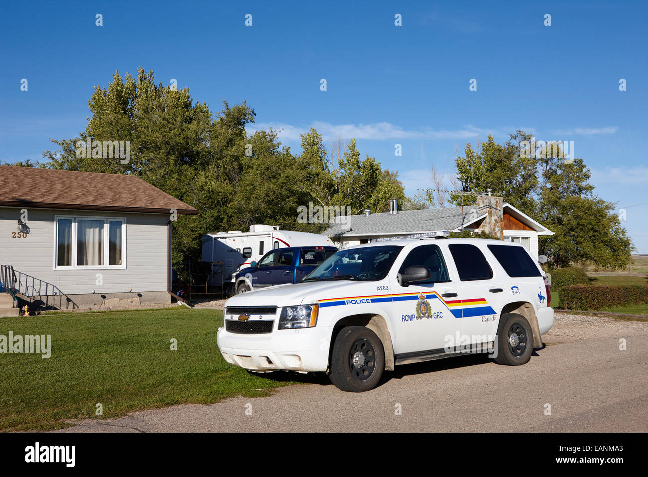 Rcmp patrulla de la policía estacionados fuera de una pequeña casa de pueblo en la zona rural de Saskatchewan Canadá Foto de stock