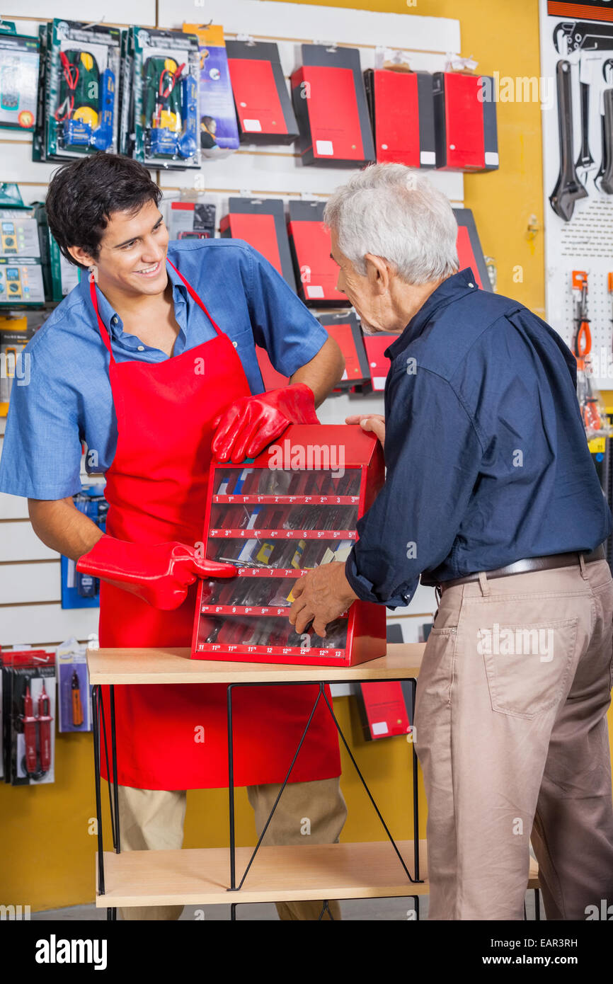 Vendedor mostrando herramientas al hombre senior en la tienda Fotografía de  stock - Alamy