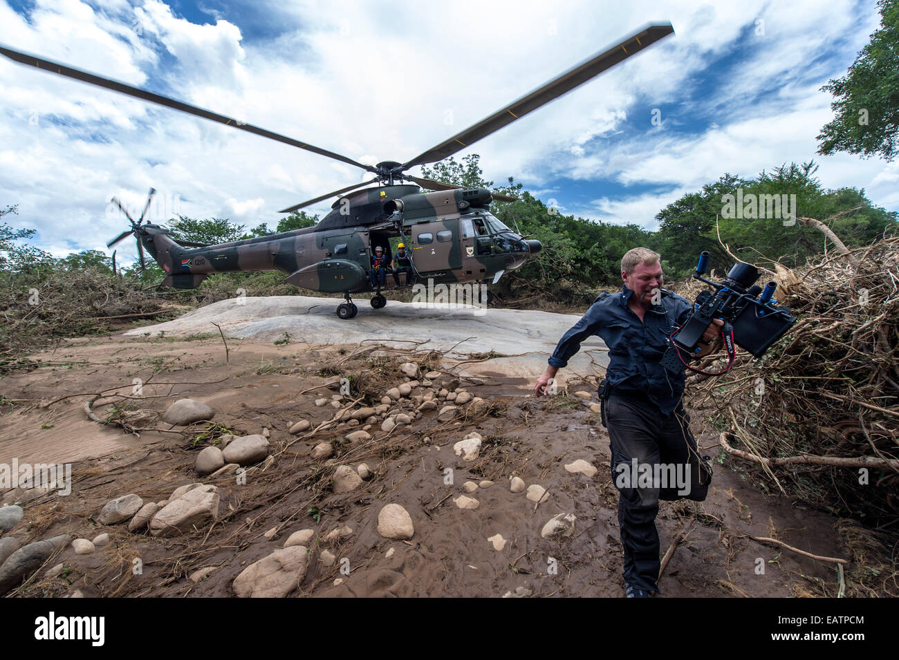 Un camarógrafo se ejecuta a partir de la corriente descendente de una fuerza aérea del helicóptero. Foto de stock