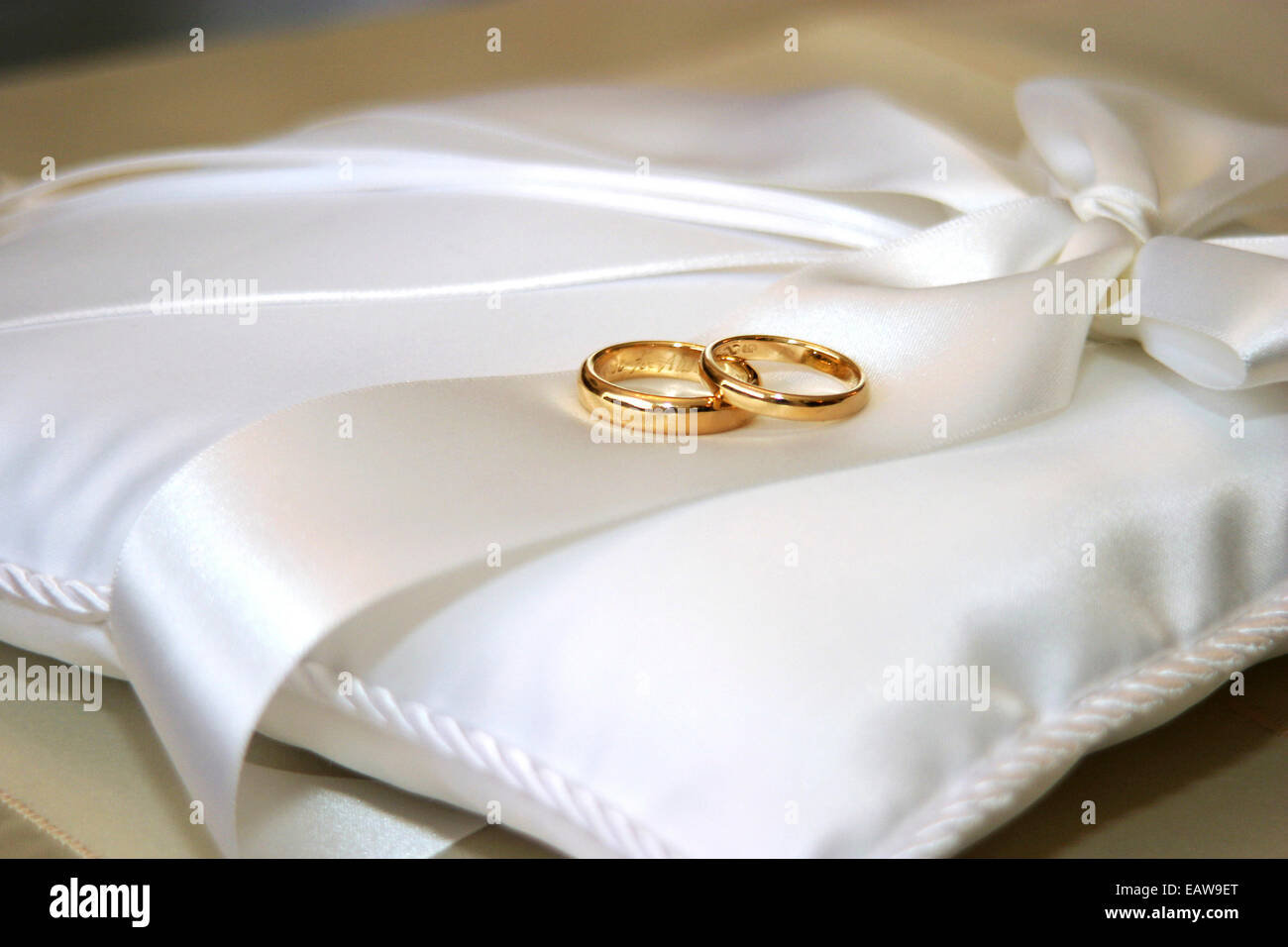 Los anillos de boda Sobre almohada de satén blanco Foto de stock