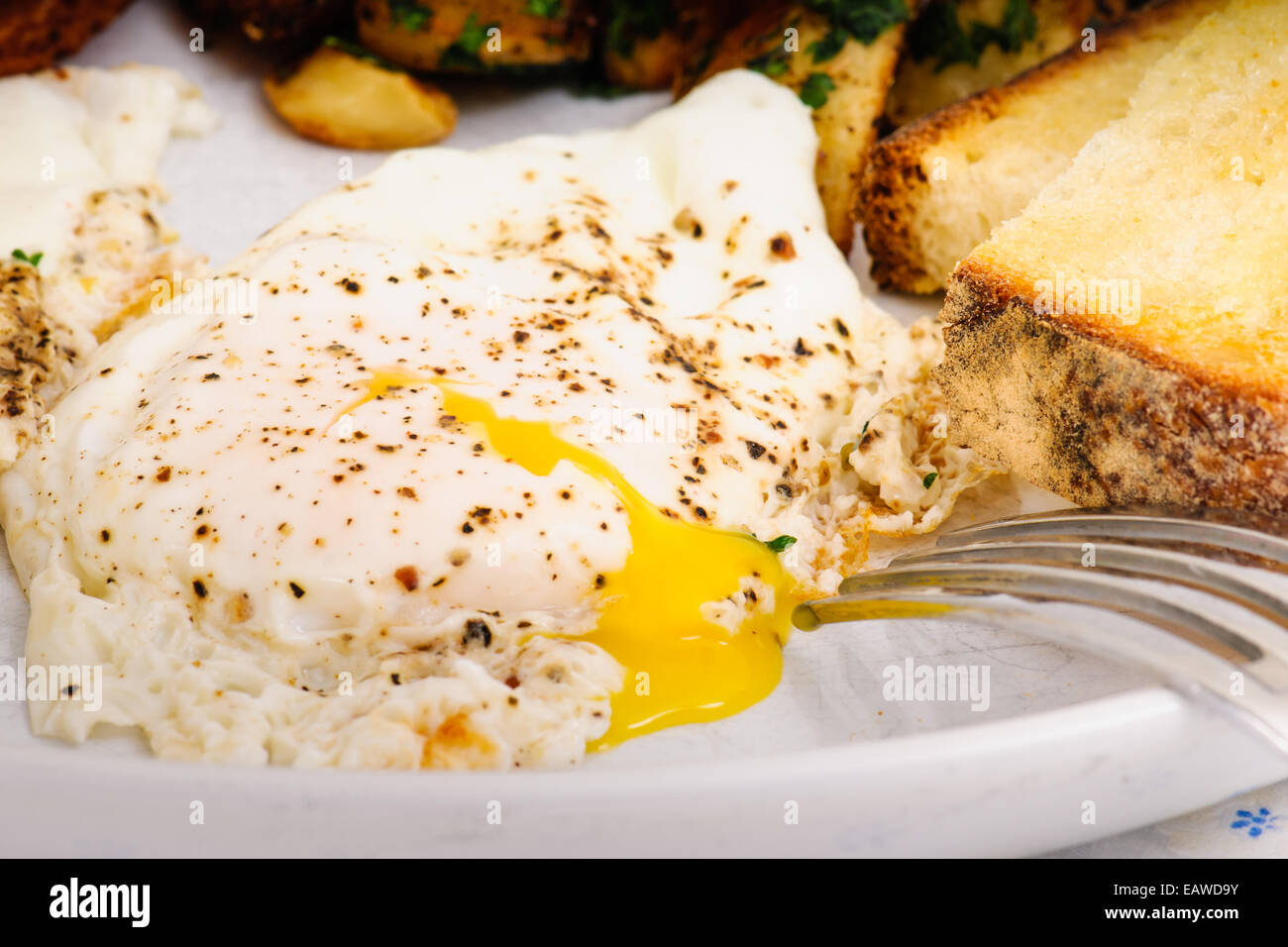 Desayuno indulgente de tocino, papa papa rallada, Sunny Side huevos, tostadas y sourdough. Foto de stock