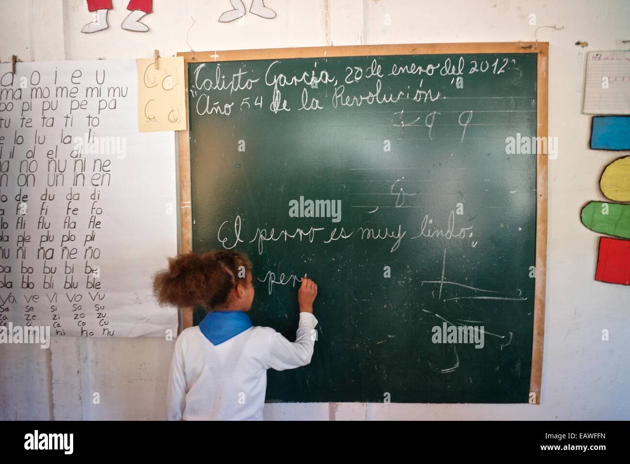 Una niña escribe en la pizarra con tiza en una escuela en Cuba Fotografía  de stock - Alamy