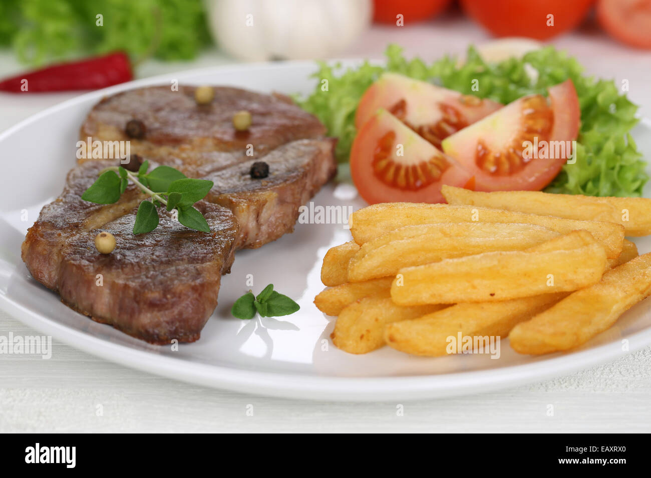Pork Chop chuleta de bistec con patatas fritas en harina de carne, verduras y lechuga en la placa Foto de stock