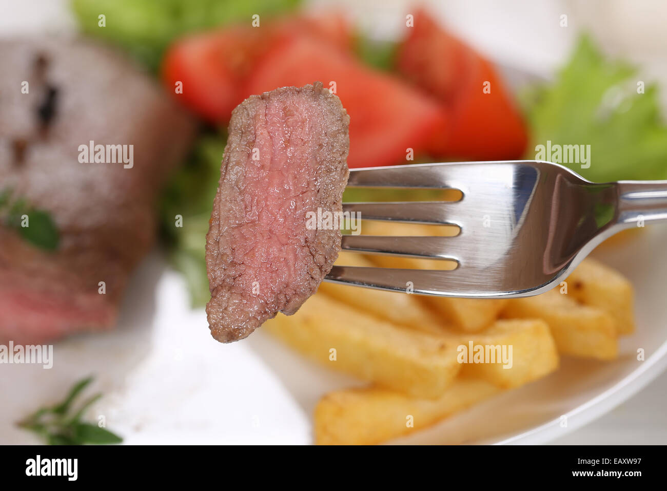 Comer un filete de carne en harina de carne con un tenedor Foto de stock