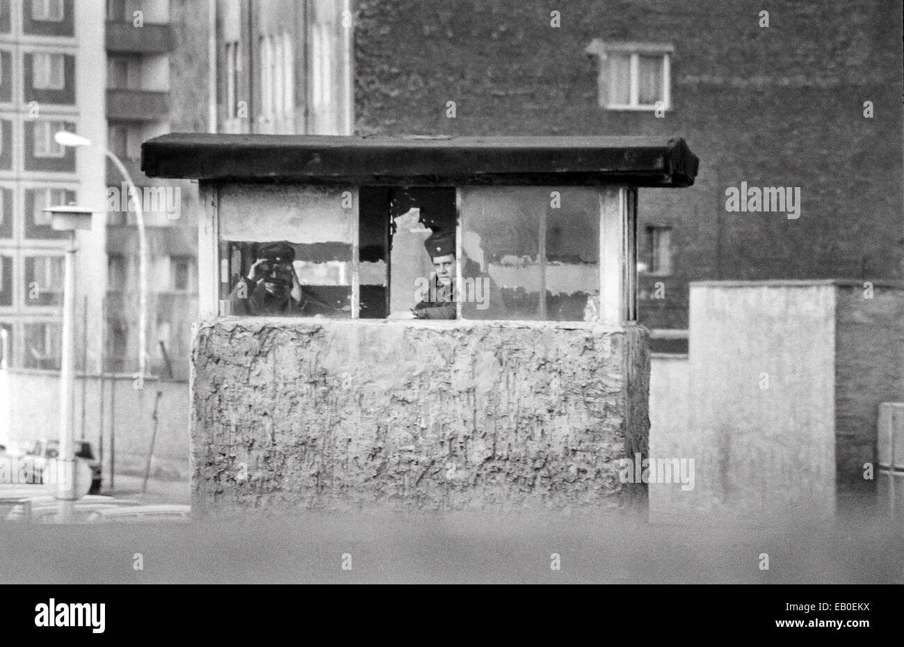 La policía fronteriza de Alemania oriental mirando sobre el muro de Berlín hacia el oeste en 1981 Foto de stock