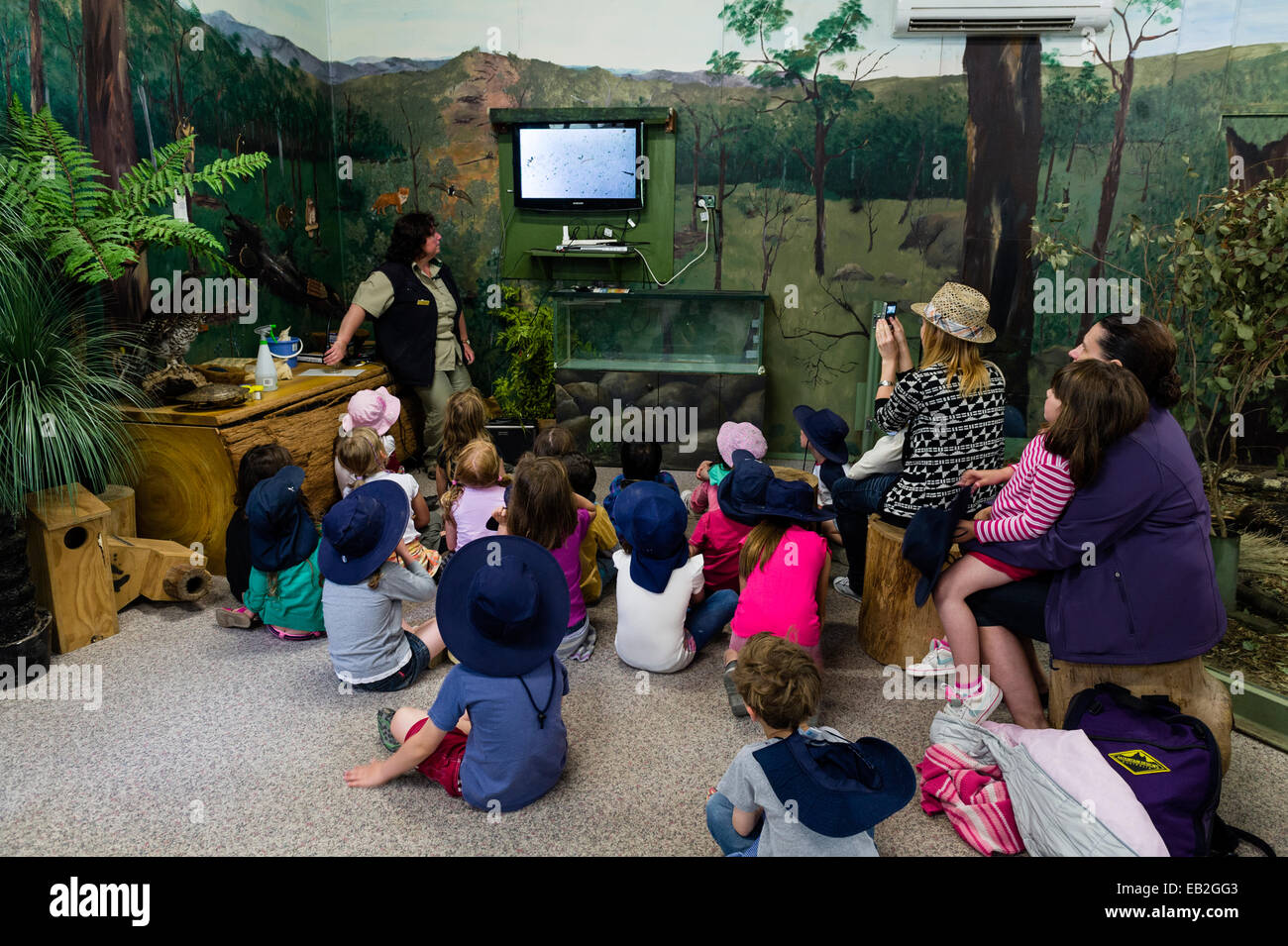 Los niños de la escuela ver estanque acuático la vida en una pantalla de televisión en un zoológico especial aula. Foto de stock