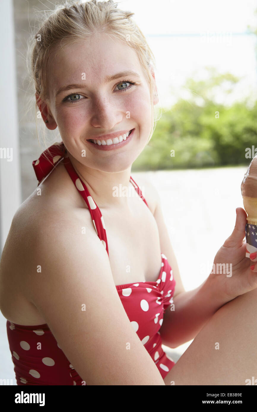 Mujer sonriente en bañador comer helado Foto de stock