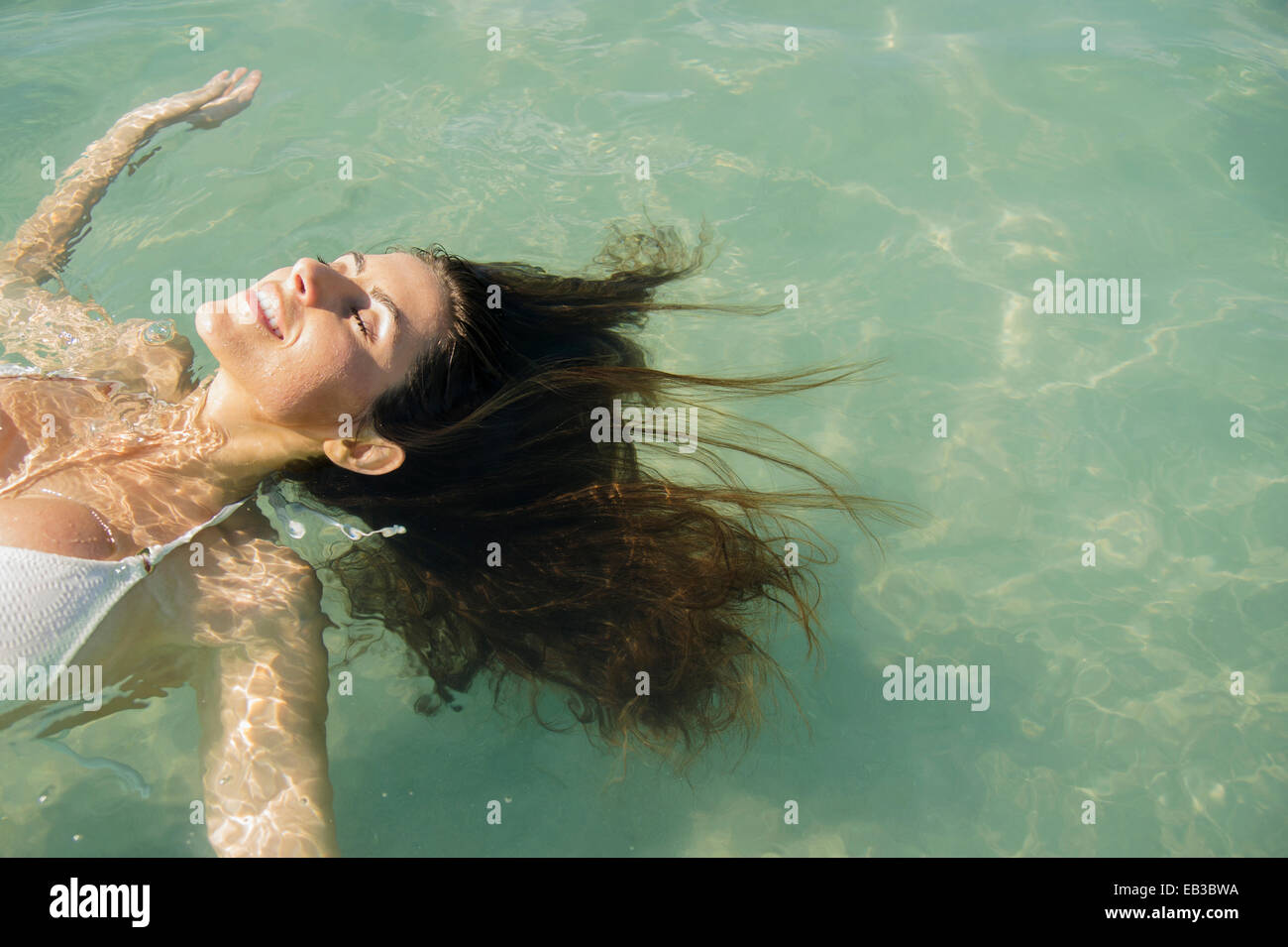 Mujer caucásica flotando en el océano Foto de stock