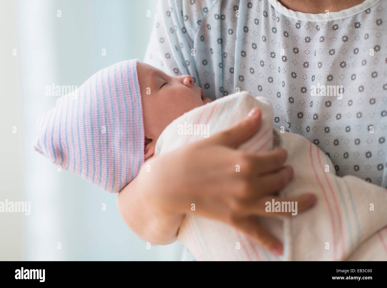 Madre sosteniendo asiáticos recién nacido en el hospital Foto de stock