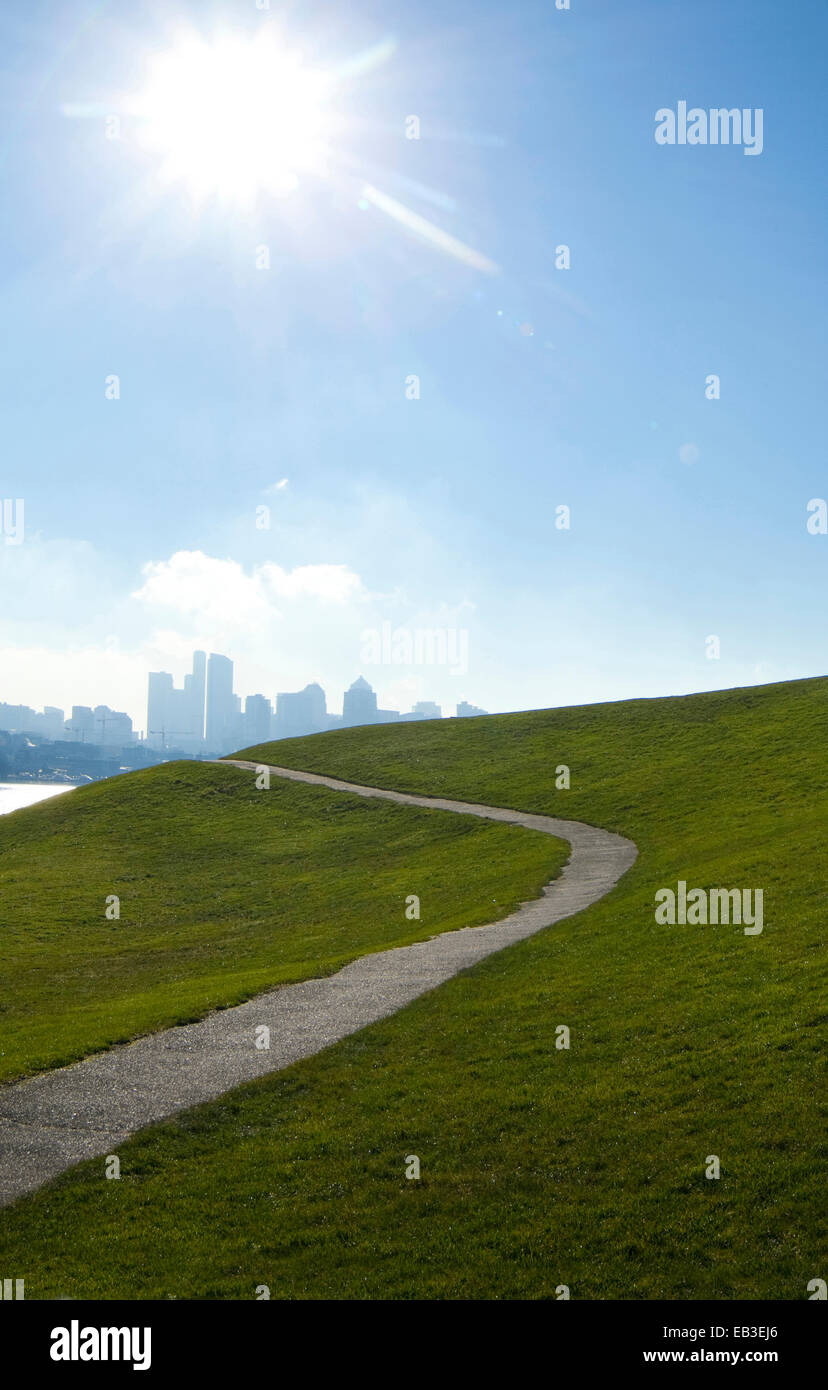 El sol brillaba sobre carretera pavimentada en laderas herbosas, Seattle, Washington, Estados Unidos Foto de stock