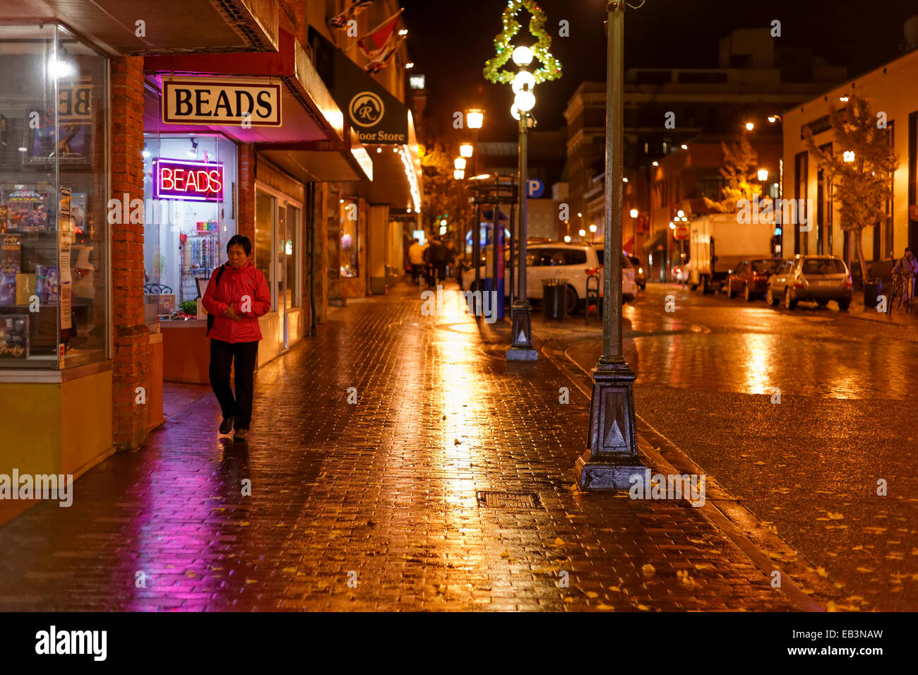 Mujer China caminando en el centro de noche lluviosa-Victoria, British Columbia, Canadá. Foto de stock