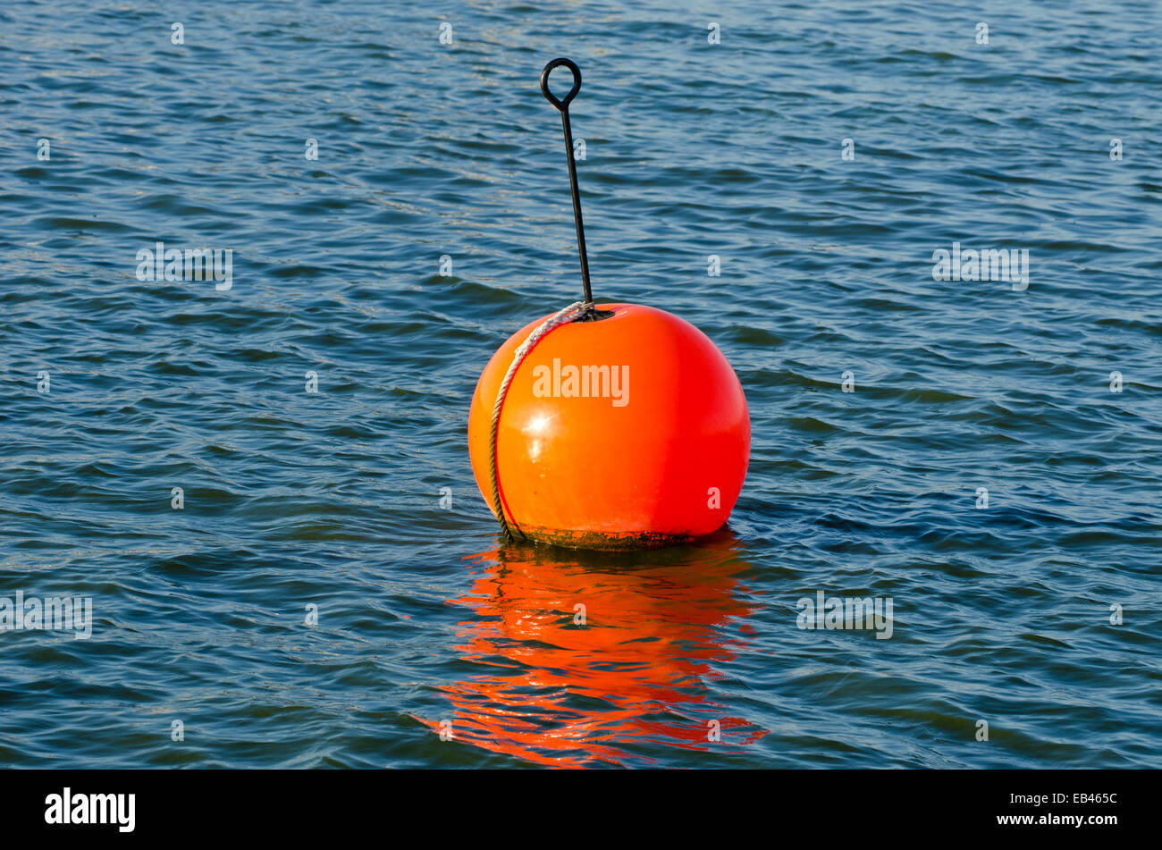 Boya de color naranja en el mar sobre el agua Fotografía de stock - Alamy