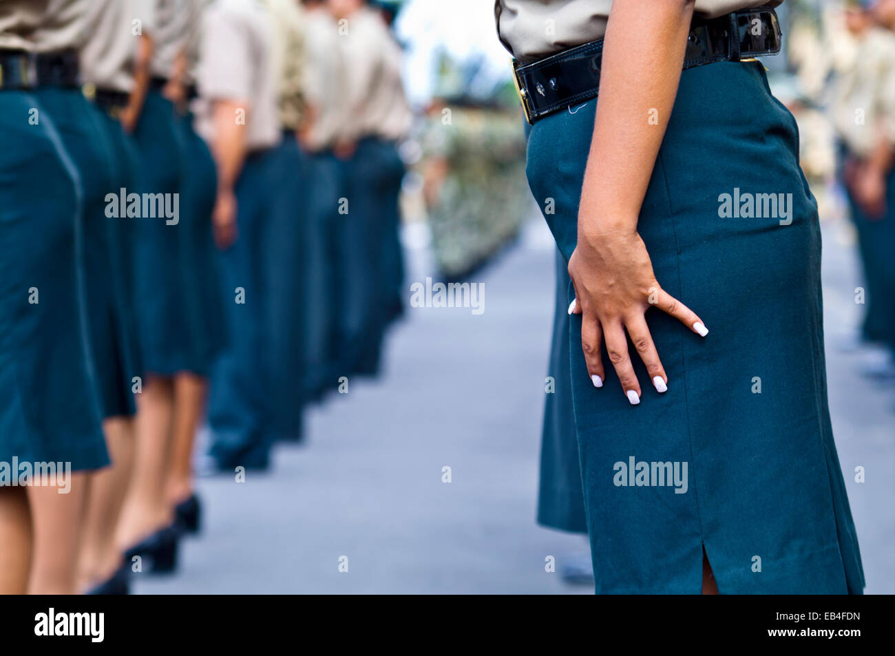 Un oficial del ejército peruano se encuentra en atención con su esmalte de uñas blancas contrastan con el azul de la falda. Foto de stock