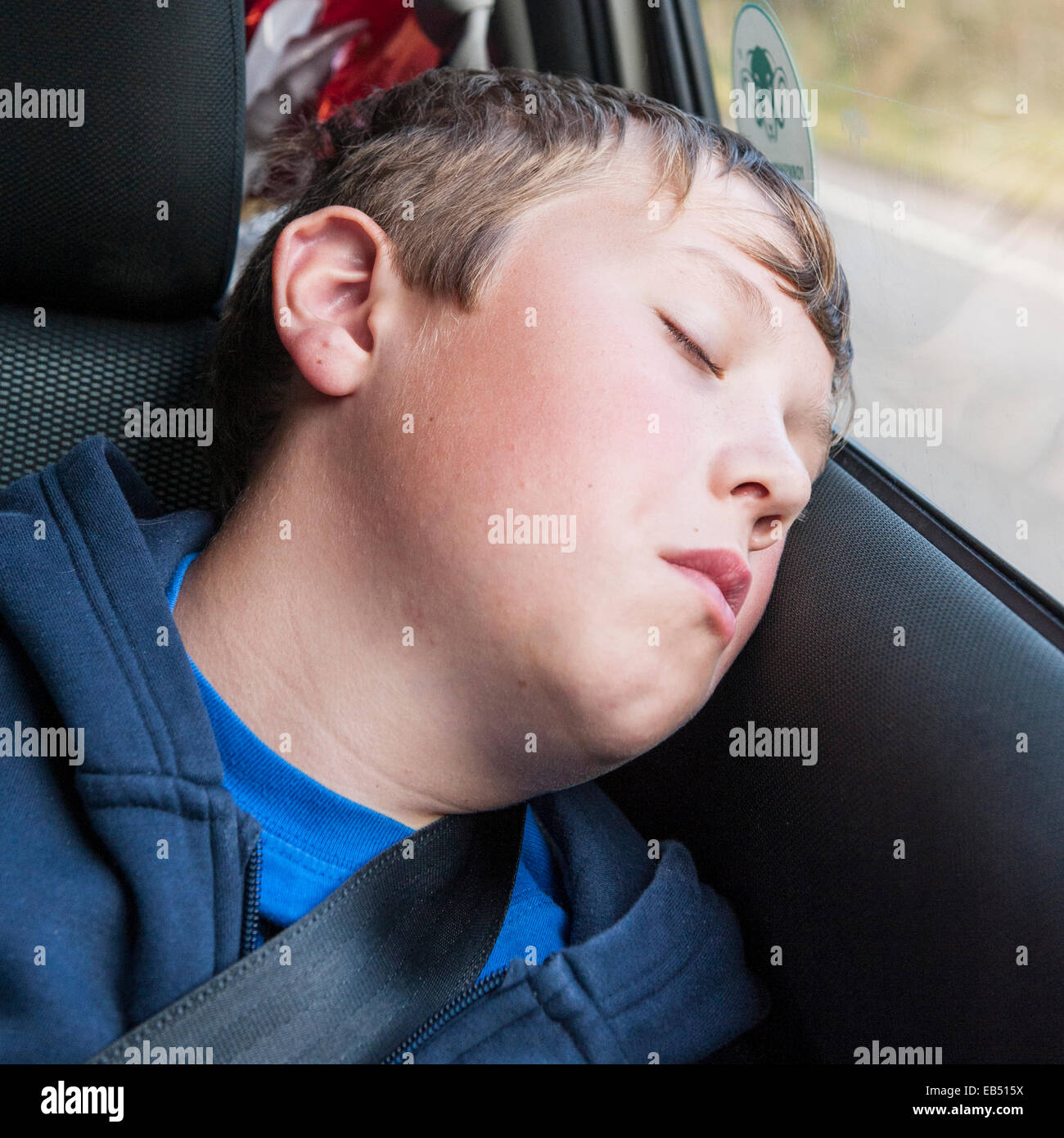 Un muchacho de 10 años durmiendo en el coche Foto de stock