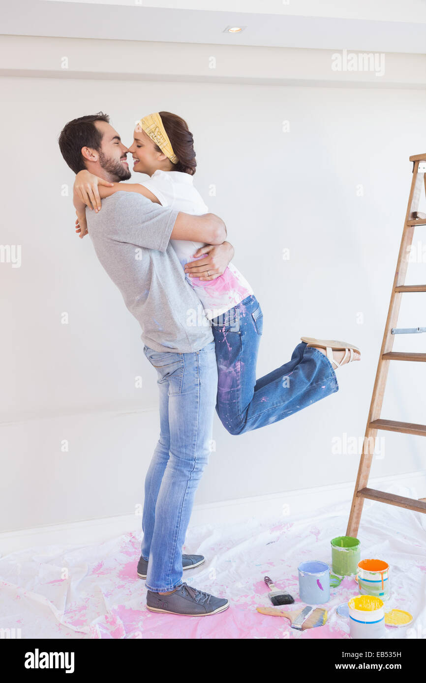 Linda pareja abrazarse mientras redecorar Foto de stock