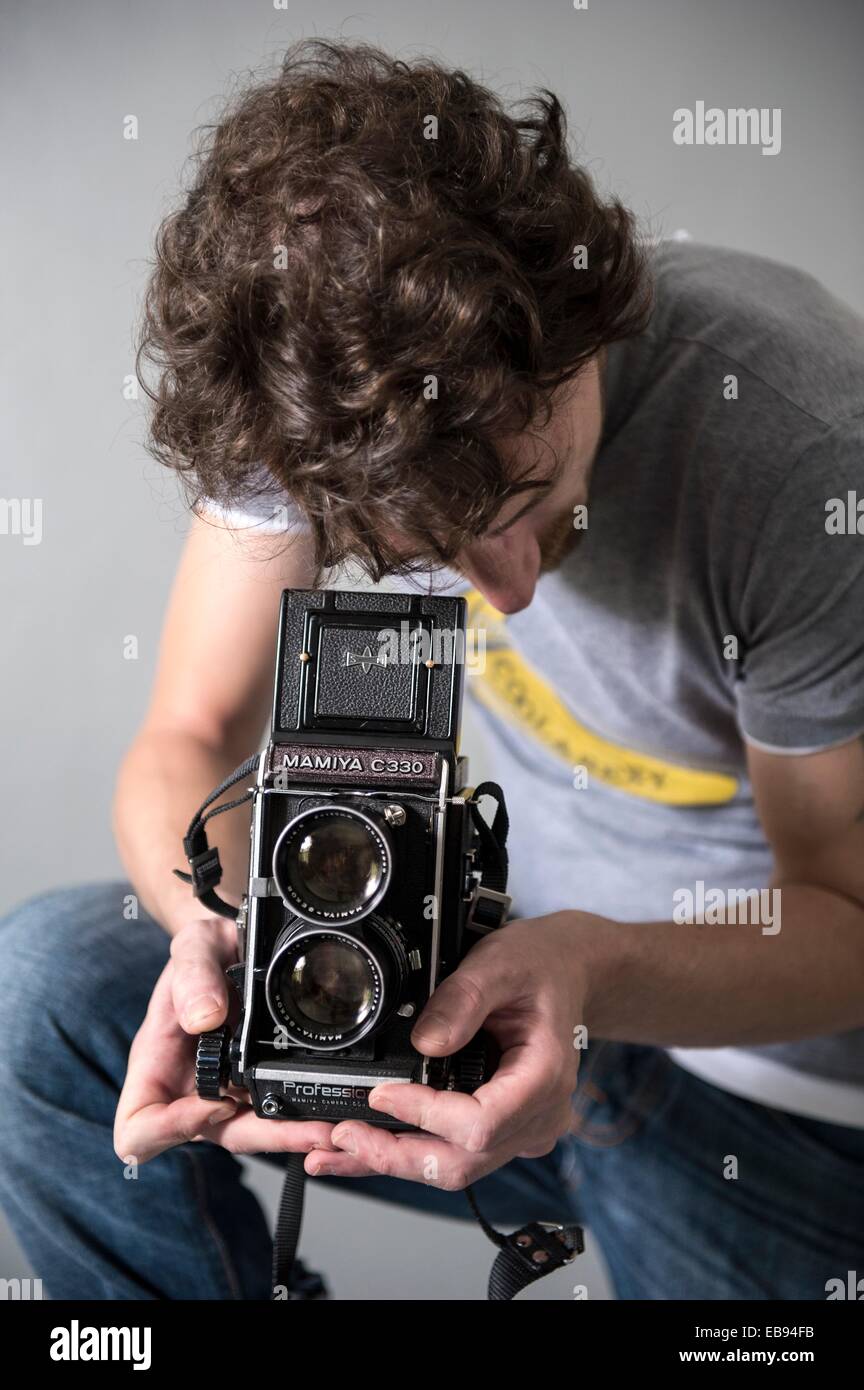 Tilburg, Holanda. Hombre con un formato medio vintage cámara réflex de  lente doble. Studio-retrato contra un fondo gris Fotografía de stock - Alamy