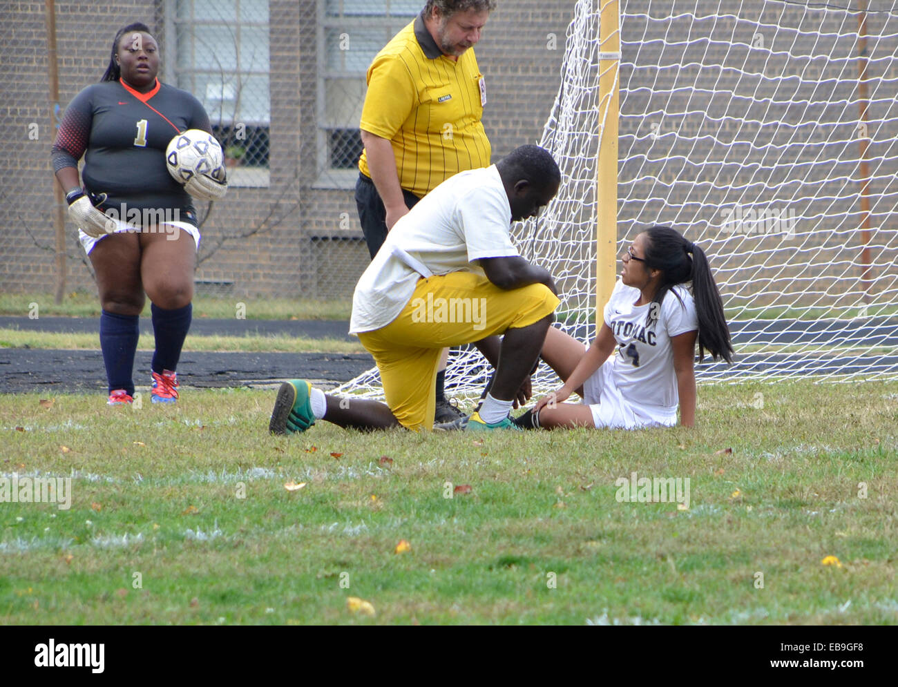 Jugador de fútbol femenino lesionado está desprotegido por el entrenador y el árbitro en un partido de fútbol en Oxon Hills, MD Foto de stock