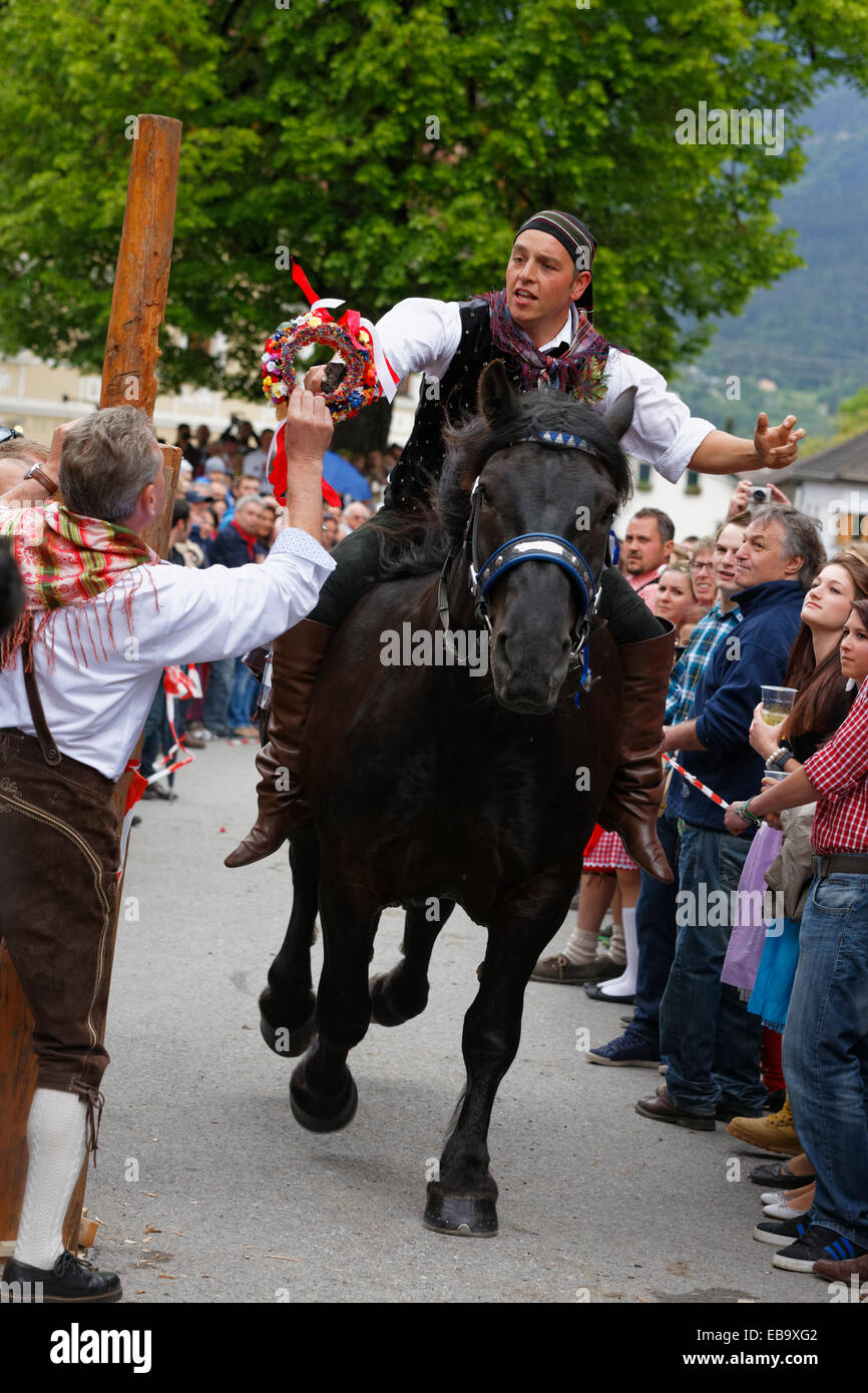 Un hombre está entregando un competidor una corona de flores, Kufenstechen, un festival tradicional y personalizado, Feistritz an der Gail Foto de stock