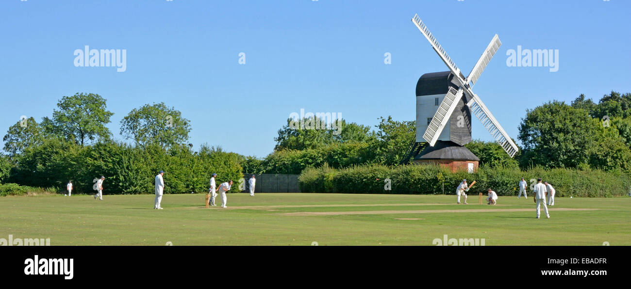 La quintaesencia de la icónica Inglaterra idílico pueblo verde partido de cricket bowler batsman & jardineros Mountnessing Post Mill más allá de la campiña de Essex, Reino Unido Foto de stock