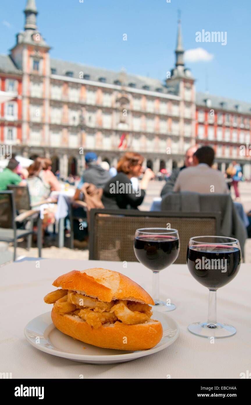 Bocadillo de calamares fritos con dos copas de vino tinto en una terraza.  Plaza Mayor, Madrid, España Fotografía de stock - Alamy