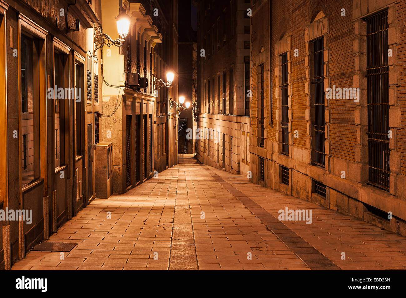 Estrecho callejón iluminado por las luces de la calle por la noche, Madrid, España Foto de stock