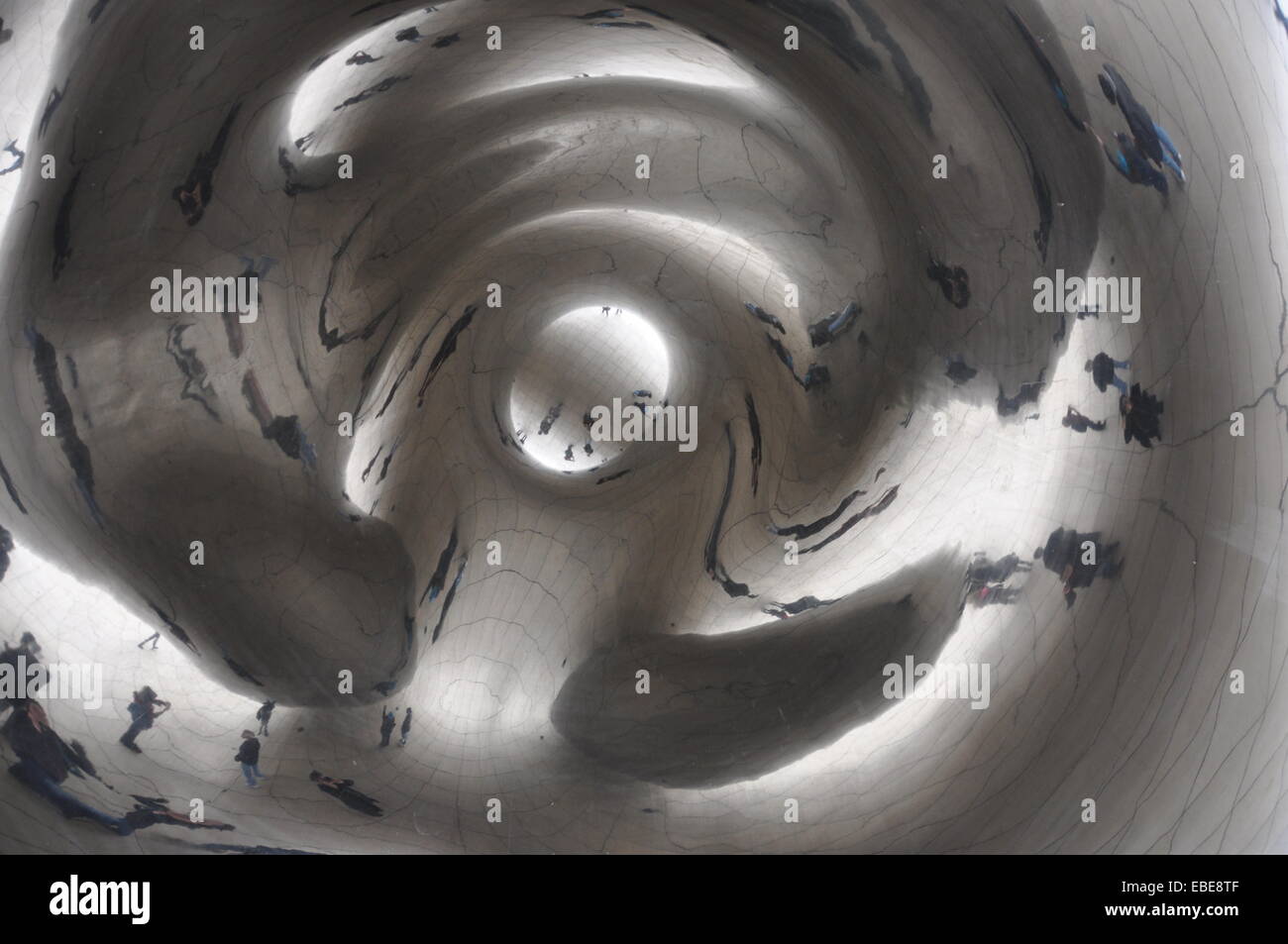Reflejo distorsionado de visitantes de pie debajo de la parte inferior o "Omphalos' de la escultura Cloud Gate en el Millennium Park. Foto de stock