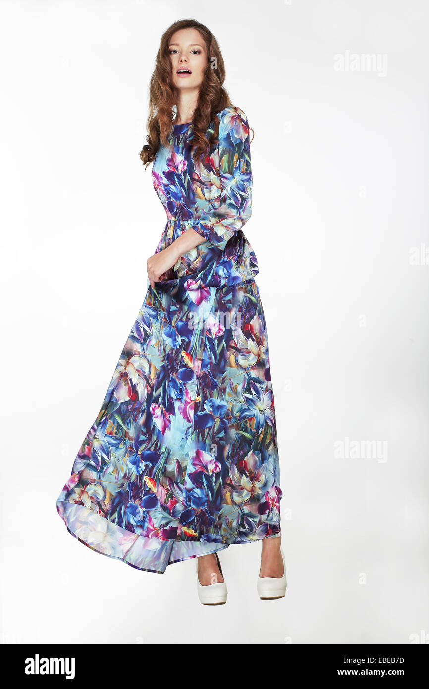 Moda elegante mujer en Azul sedoso vestido florido Foto de stock