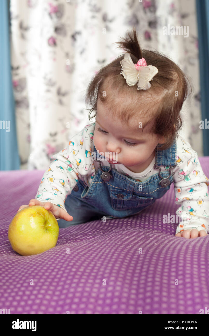 Pequeña niña sonriente con una manzana adentro Foto de stock