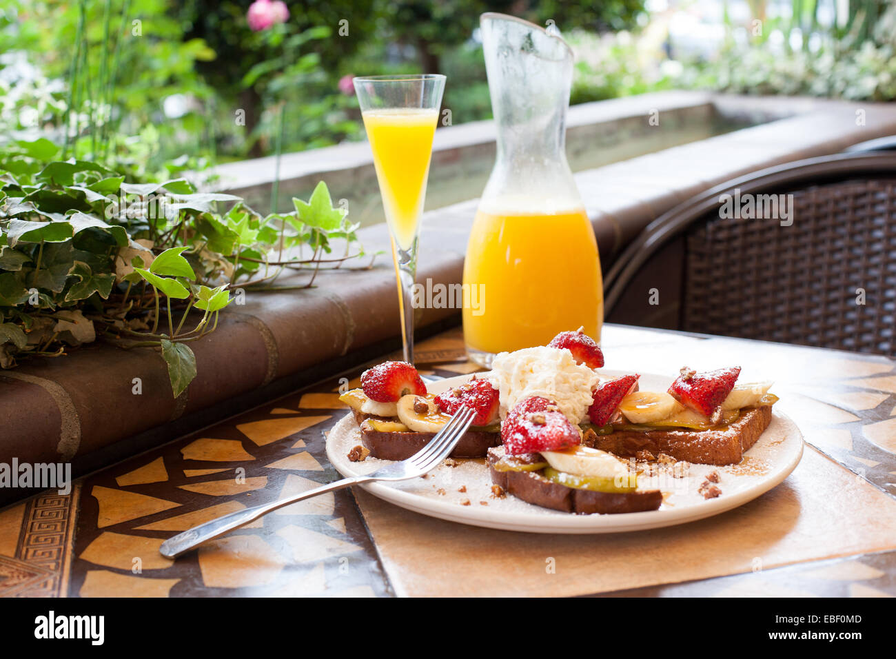 Tostadas francesas y mimosa en el brunch en el patio jardín ajuste Foto de stock