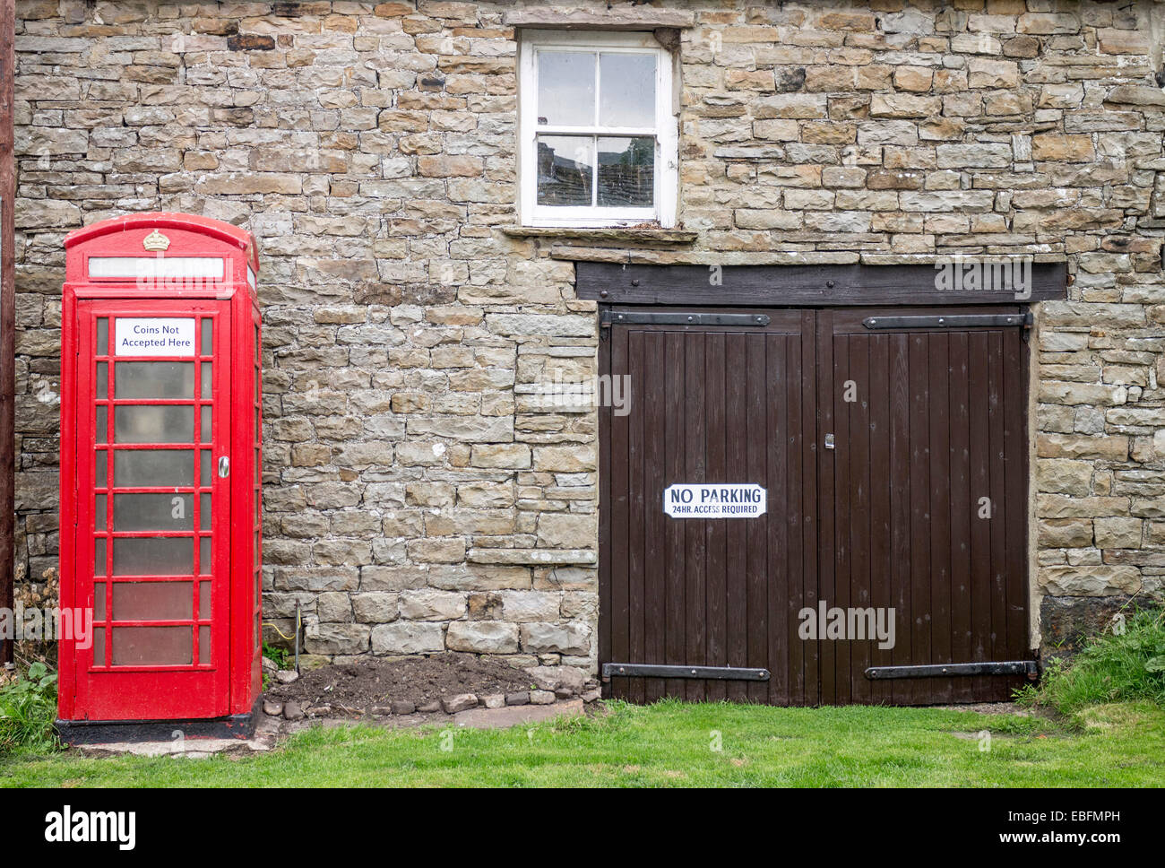 No hay aparcamiento aviso en la puerta del garaje y teléfono caja en Thwaite, North Yorkshire. Foto de stock