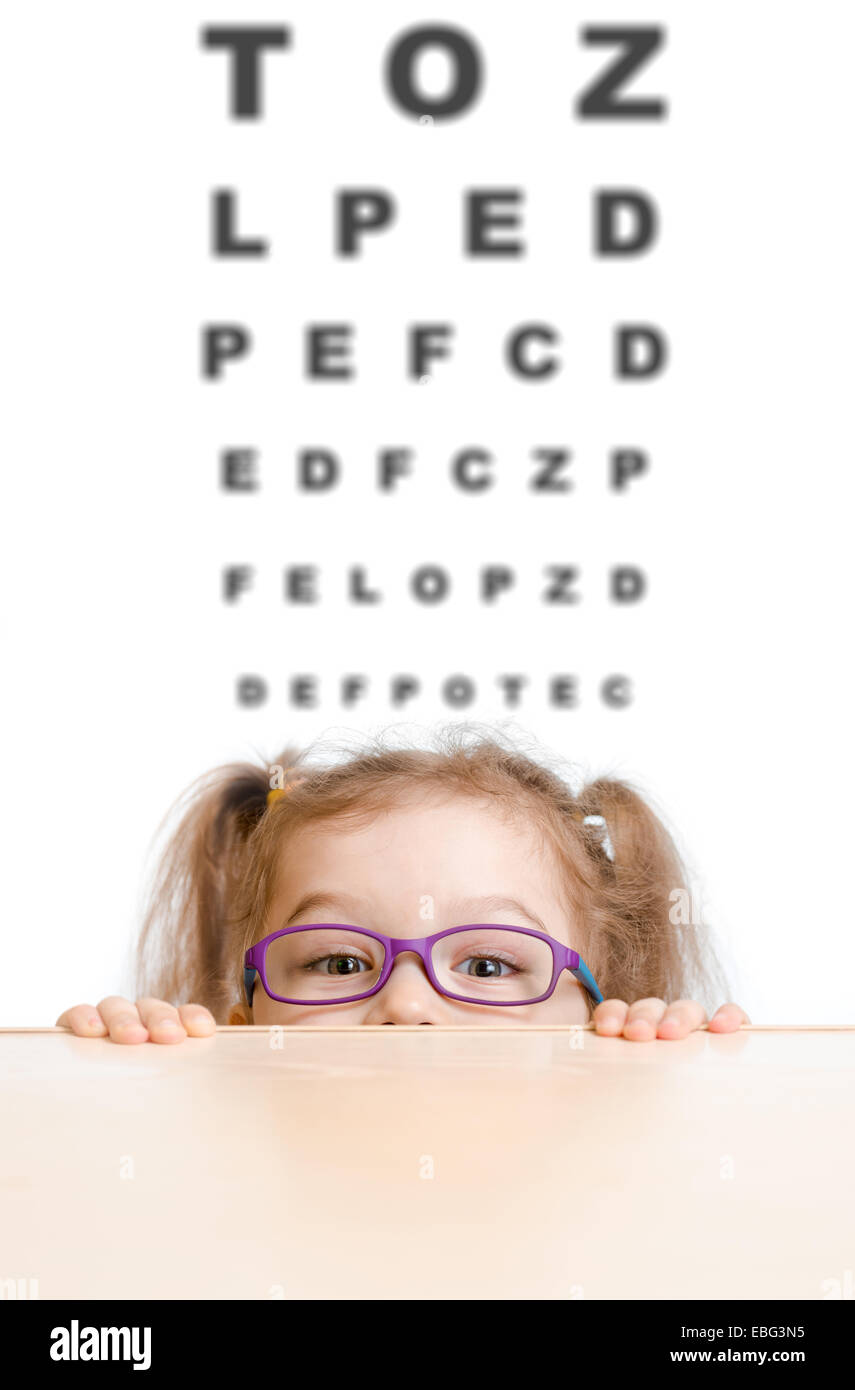 Funny Girl en anteojos con tabla optométrica Foto de stock