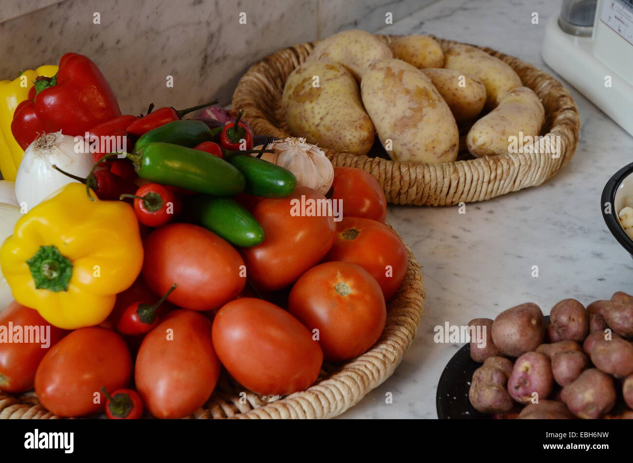 El rojo, el amarillo y el chile jalapeño con tomates, ajos y cebollas junto a las papas y papas andinas. Foto de stock