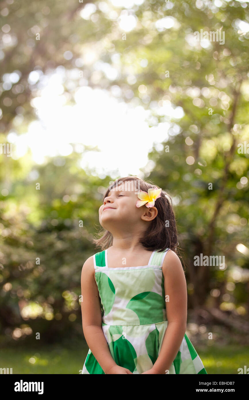 Muchacha en el jardín, vistiendo flor en el pelo Foto de stock