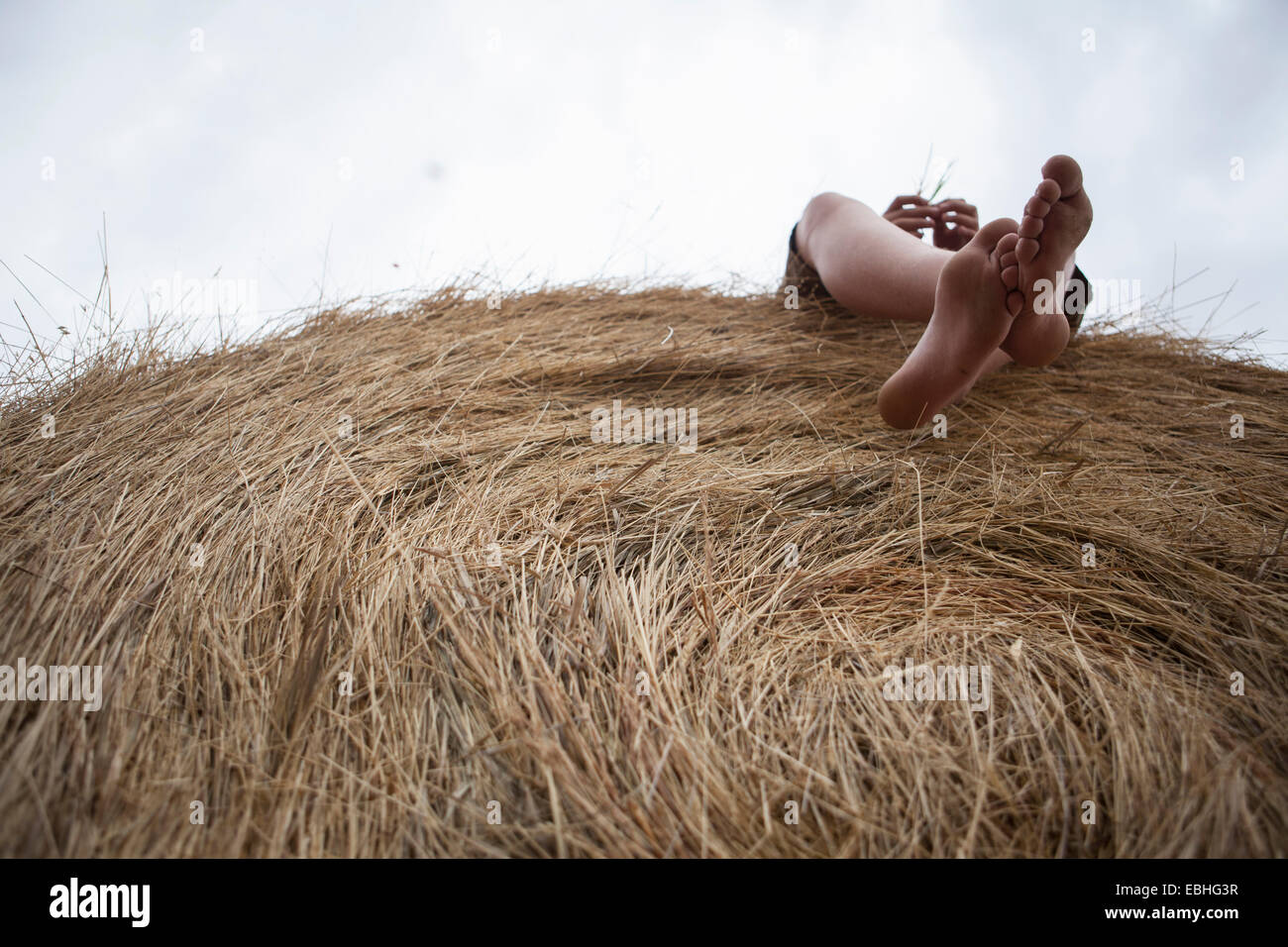 Pies de adolescente que yace en el pajar, Dakota del Sur, EE.UU. Foto de stock